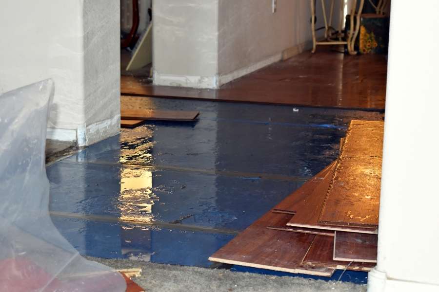 Un sol inondé avec des lames de parquet retirées suite à une déclaration d'un dégât des eaux.